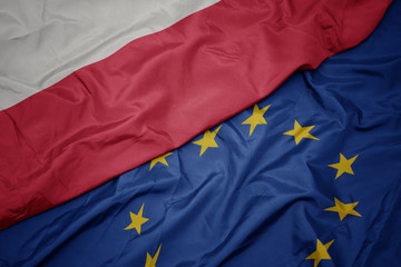 waving colorful flag of european union and national flag of poland.