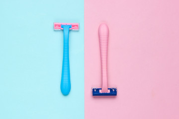 Minimalistic beauty concept. Two plastic razor on blue pink pastel background. Top view