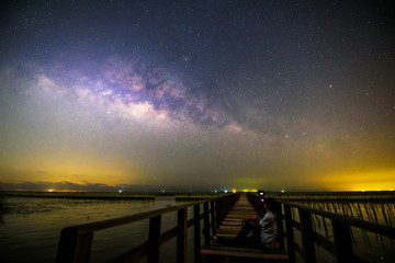 milky way with the man sitting at the bridge