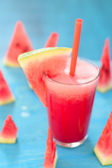 Watermelon smoothie with fresh watermelon slices on blue background