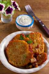 Potato pancakes with bacon and sour cream. Vegetable fritters, draniki - popular dish in many countries