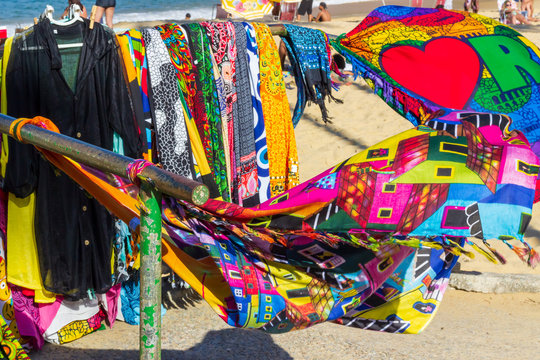 Colorful Brazilian canga (beach towels, pareo), Rio de Janeiro, Brazil. People sunbathing in the background. Brazilian prints. 2017