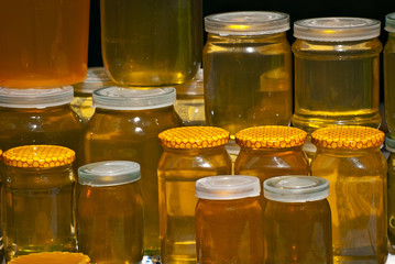 Lots of assorted honey on the table. Jars of sweets are sold at the fair.