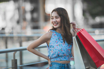 Happy time to shopping concept , Asian woman holding shopping bags at mall centre.