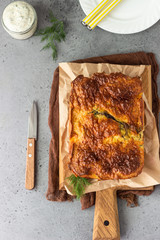 Pie with liver, egg and dill filling on a wooden cutting board. Healthy nutrition lunch or dinner.