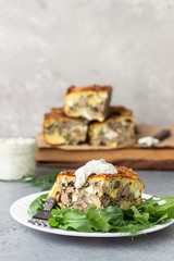 Pie with liver, egg and dill filling on a white plate with sauce. Healthy nutrition lunch or dinner.