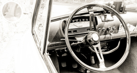 Road trip in a vintage car, close up of the steering wheel and dashboard. Vintage high key look and space for text. Black and white photography - obrazy, fototapety, plakaty