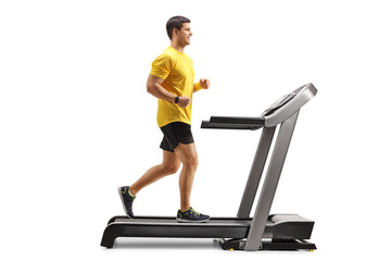 Obraz na płótnie Canvas Young man running on a professional treadmill