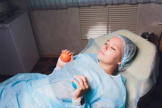 close up of hands patient doing exercise with rubber ball or squeezing a stress ball or small heart for Loosen the muscles and The blood flow better. health, medicine, people concept.
