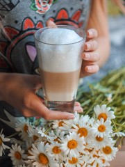  latte coffee in the hands of a girl with flowers
