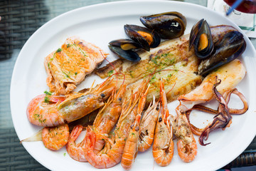 Seafood with king prawns, fish, octopus, mussels on a white plate