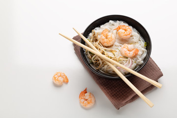 Traditional vietnamese noodle soup pho with shrimps in black bowl