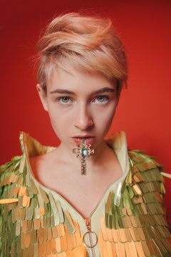 Young woman with jewelry cross in mouth