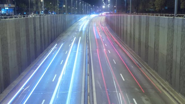 Timelapse of fast moving busy traffic at night under the bridge. Baneasa Bridge in Bucharest, Romania.