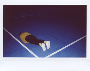 Woman lying on blue court