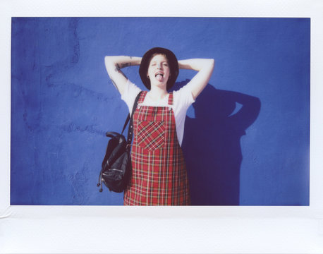 Modern playful woman in dress showing tongue