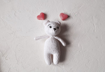 One cute knitted white bear and a marmalade in the form of a heart on a white background