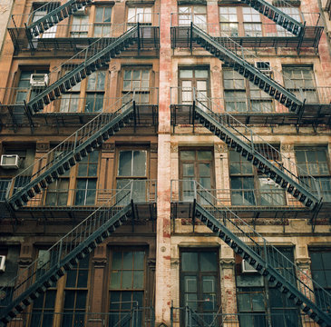 An old brick building with merging fire escape stairs