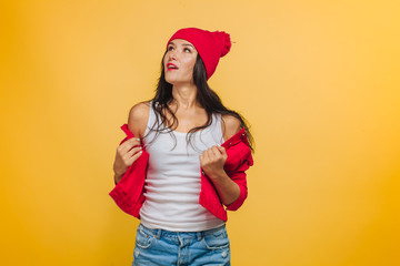 Girl on yellow background in red jacket and hat