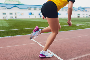 Cropped shot of young female athlete launching off the start line in a race. Female runner started...