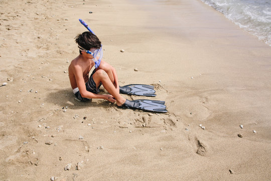 Asian teenage boy putting on his snorkel gear - Powered by Adobe