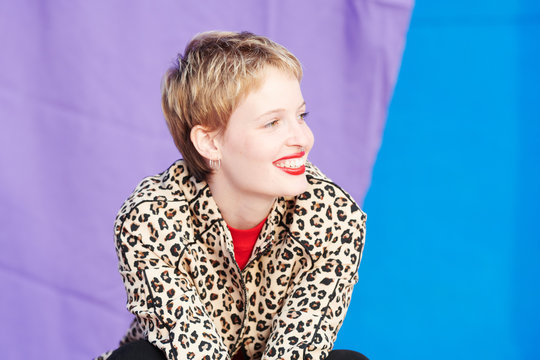 Pretty happy woman with red lips in leopard jacket.