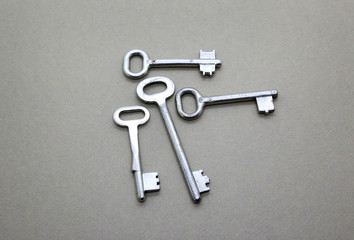 Many old vintage keys on a beige background