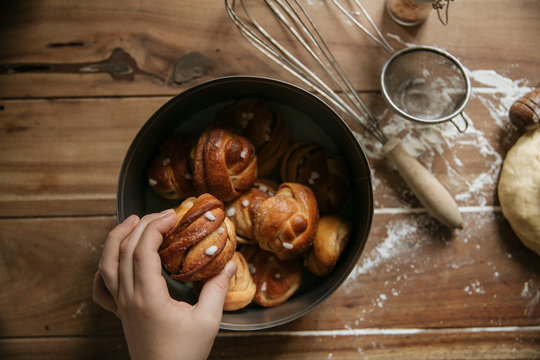 Crop hand taking bun from bucket