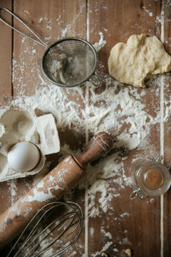 Piece of dough and egg near utensils