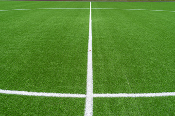 Green artificial grass soccer sports field with white stripe line