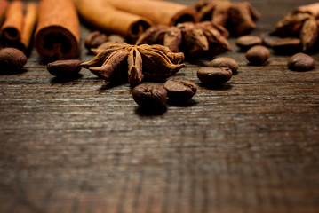 Set for mulled wine: anise stars, cinnamon sticks, coffee grains on wooden vintage background. Template for design. Macro.