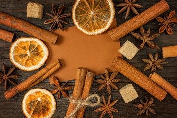 Background with set for mulled wine: anise stars, cinnamon sticks, cane sugar pieces, dried orange on a wooden vintage background. top view.  Template for design.