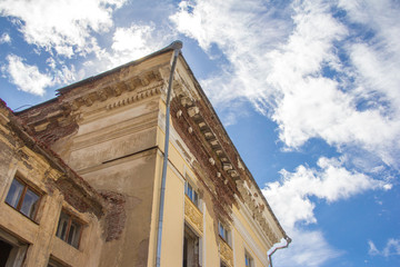 Naklejka premium The facade of an old brick house on a background of blue sky on a sunny day