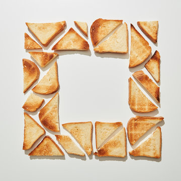 Square frame of pieces of fried toast on a gray background with copy space. Flat lay