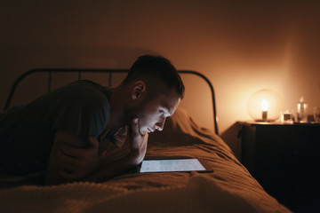 Teenager reading electronic book in cozy room