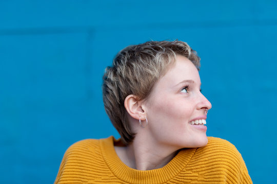 Smiling blonde woman with septum in yellow.