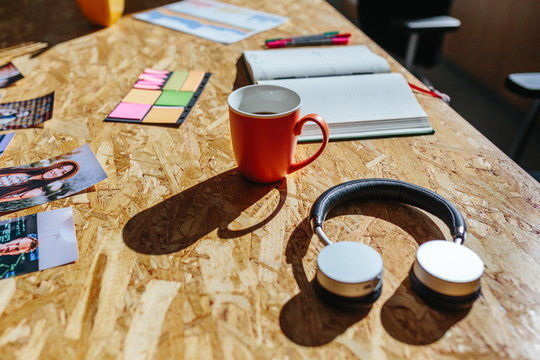 Modern headphones and coffee on a wooden office table