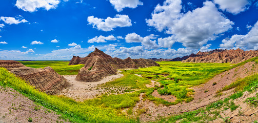 Panorama of formations with sunny skies at Badlands National Park.