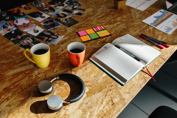 Modern headphones and coffee on a wooden office table