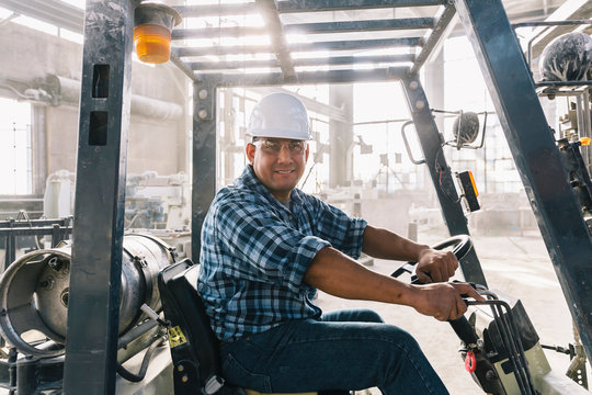 Portrait of Hispanic man at Work on Forklift