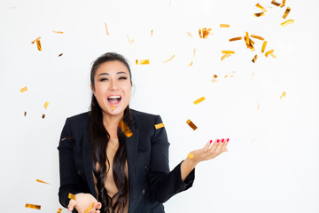 woman  in suit blowing confetti. Studio shot   
