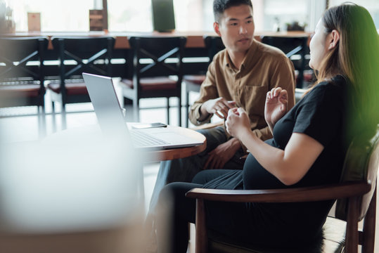 Pregnant woman and a colleague taking in cafe