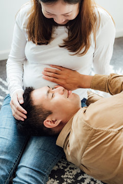 Pregnant couple sitting at home