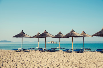 Beautiful beach in Greece Chalkidiki with straw umbrellas and no people Selective focus
