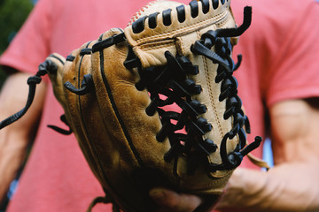 Fototapeta na wymiar Baseball player with ball in glove close up, shows detail in mitt stitching for sports game equipment.