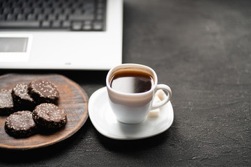 Office workplace. Desk table with laptop computer, cup of coffee and treats. Top view with copy space