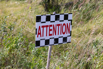 Attention sign in the grass lolly close up