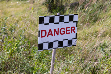 Danger sign in the grass lolly close up