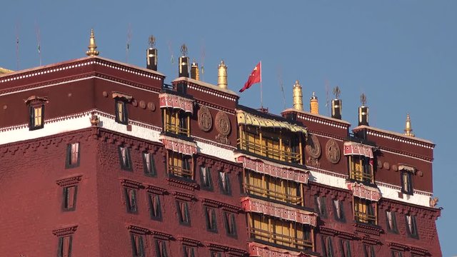 Chinese national flag waves on top of Potala Palace in Lhasa, symbolic political cultural influence in Tibet