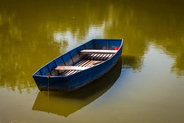 Old blue vintage wooden boat in a lake